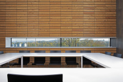 Modřínový obklad prochází všemi částmi společných kanceláří, je jím obložena i exteriérová část zasedačky přecházející do balkonu