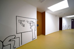 Význam středové zokruhované chodby posilují pravidelně řazené světlíky, dodávající pocit vertikálně neukončeného prostoru