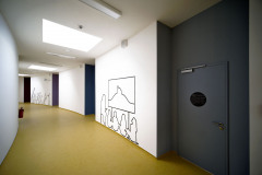 Význam středové zokruhované chodby posilují pravidelně řazené světlíky, dodávající pocit vertikálně neukončeného prostoru