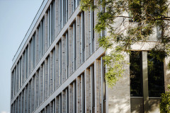 Prosklená fasáda s cihelným obkladem navazuje na některé stavby z první poloviny 20. století ve městě