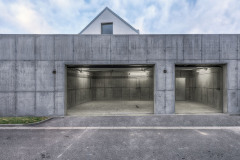 Pohledový beton garáže je doplněn o pohledové pečlivě rozmístěné instalace