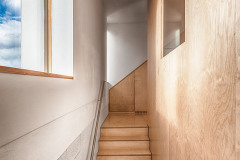 Hladký povrch podlah a nábytku v kontrastu s režným zdivem