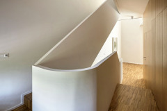 Expresivně modelované schodiště ve třetím domě tvoří jakýsi kloub stavby v místě, kde se její hmota zalamuje