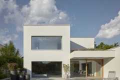 Dům se otevírá k terase a bazénu do zahrady; provozně i objemově je rozdělen do čtyř bloků