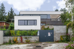 Dvoupodlažní část je obložená dřevem, zakončuje ji bílá, částečně prosklená deska. Přízemní část má bílou omítku