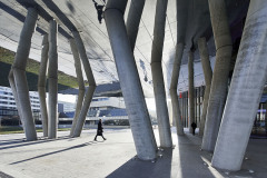 Exteriérový podhled tvoří zrcadlově lesklá kovová plocha, která v kombinaci s umělým osvětlením a vodním prvkem v dlažbě opticky zvyšuje šestimetrovou světlost u hlavního vchodu