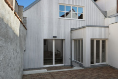 Část domu obrácená do dvora má novou provětrávanou fasádu s velkými okny