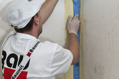 V rámci realizace hydroizolační vrstvy je nutné nejprve ošetřit namáhaná místa (styk podlah a stěn) Hydroizolační páskou, která je vložená do čerstvé první vrstvy hydroizolačního nátěru Baumit Baumacol Proof.