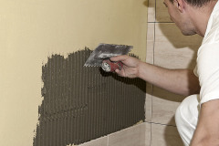 Po vyzrání hydroizolačního souvrství je možné lepit obkladové prvky. Lepicí maltu je nutné nanášet na podklad ve 2 pracovních krocích. V prvním nanést tenkou kontaktní vrstvu. Ve druhém na ještě mokrou vrstvu nanést ozubenou stěrkou odpovídající vrstvu lepicí hmoty pod úhlem 45–60°.