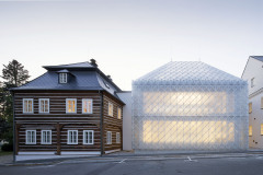 Plášť i střechu jedné z novostaveb pokrývají skleněné tvarovky. Vznikl tak objekt, který svým výtvarným řešením odkazuje na tradici sklářství a zároveň vytváří novou identitu místa