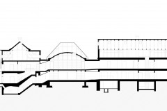 Řez třemi propojenými objekty, prostřední z nich je novostavba