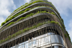 Nároží do ulice je měkce modelované, podlaží nepravidelně ustupují směrem vzhůru. Před fasádou poutají pozornost proplétané, ohýbané kovové konstrukce.