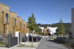 Fasáda části budov kombinuje omítku s obkladem z červeného cedru