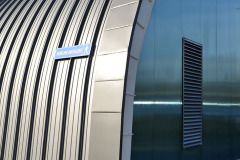 Na obloukové části vnější stěny a střešním plášti jsou lakované hliníkové profily, další část fasády kryjí plechové kazety a polykarbonátový obklad