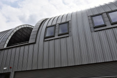 V kovem obloženém tunelu jsou jen občas v patře prolomena okna a mezi nimi několik atrií